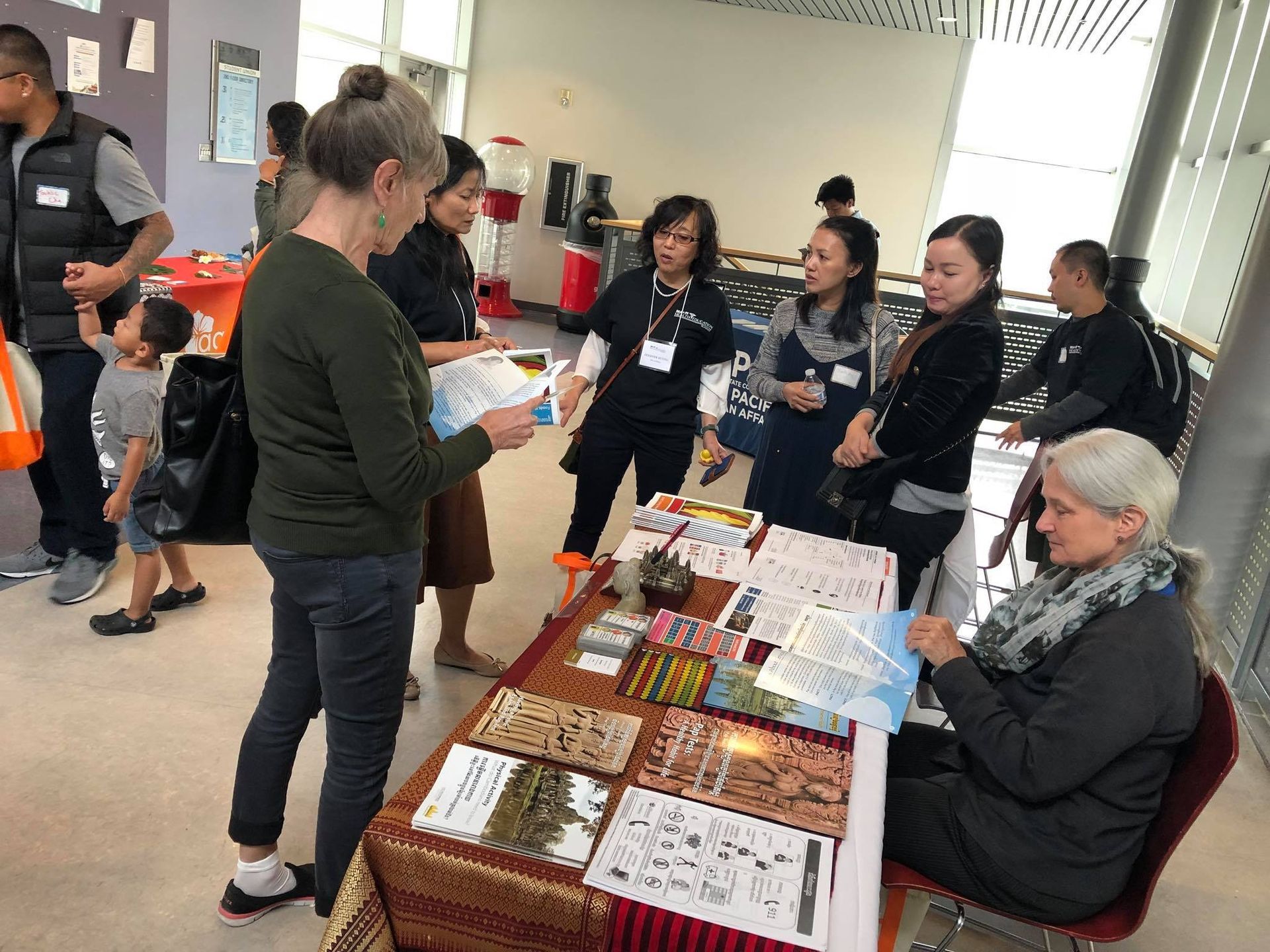 A group of people are standing around a table in a room.
