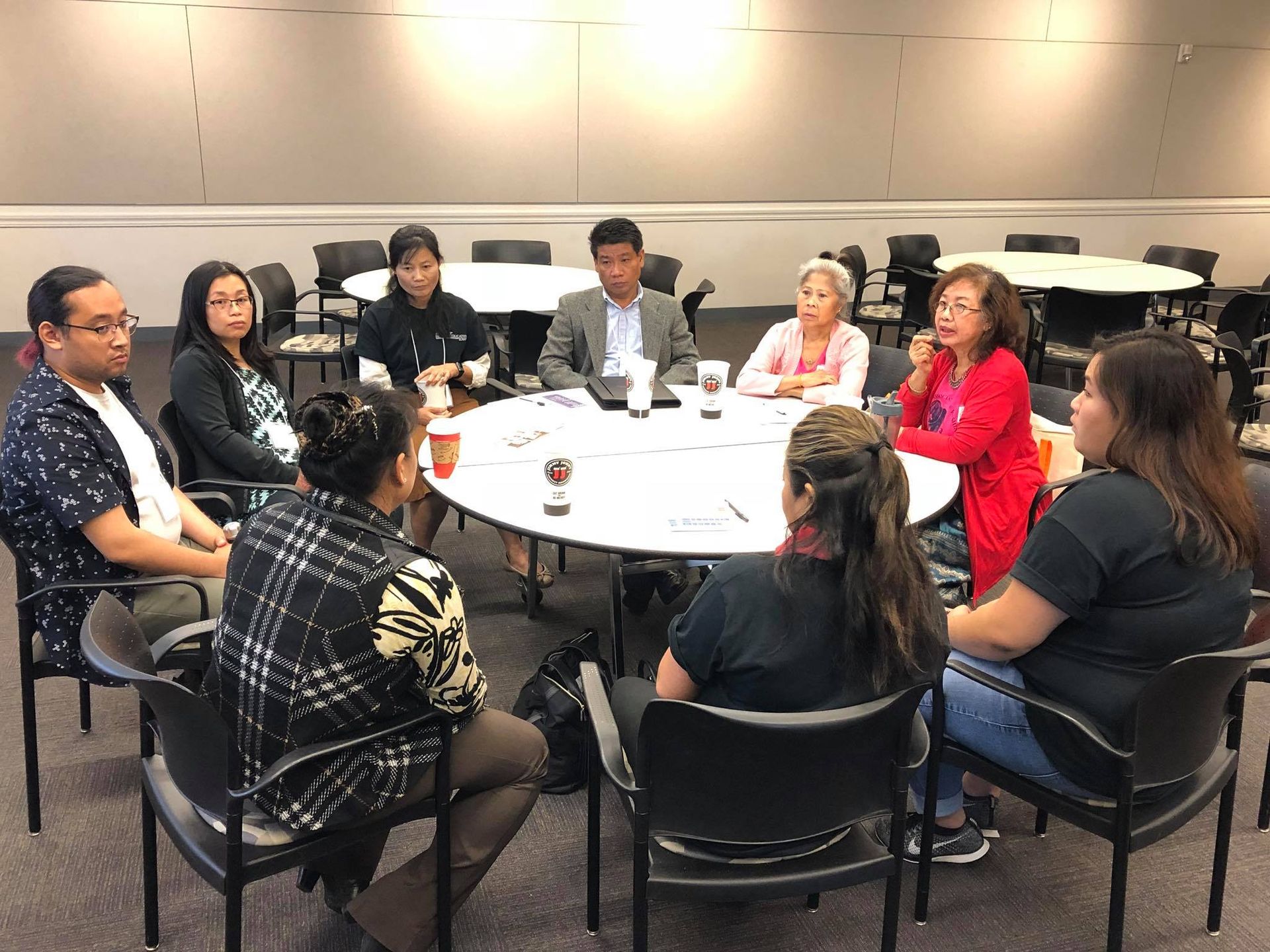 A group of people are sitting around a table in a room.