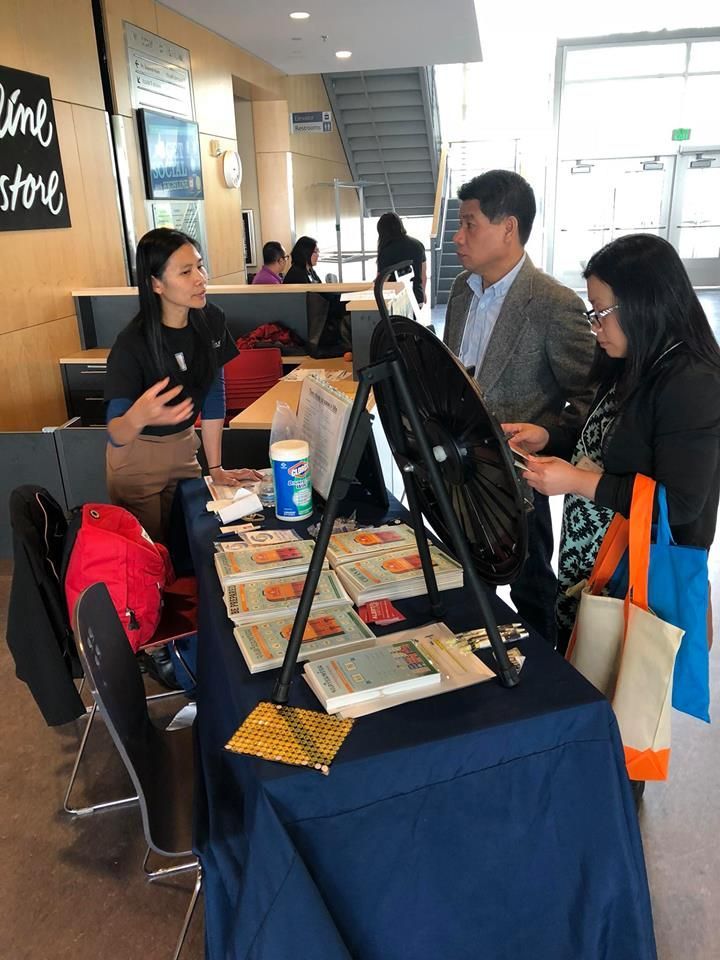 A group of people are standing around a table with books on it.