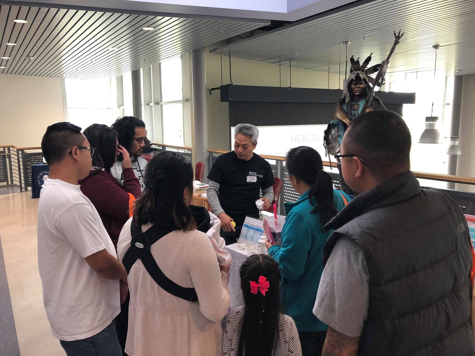 A group of people are standing around a table in a room.