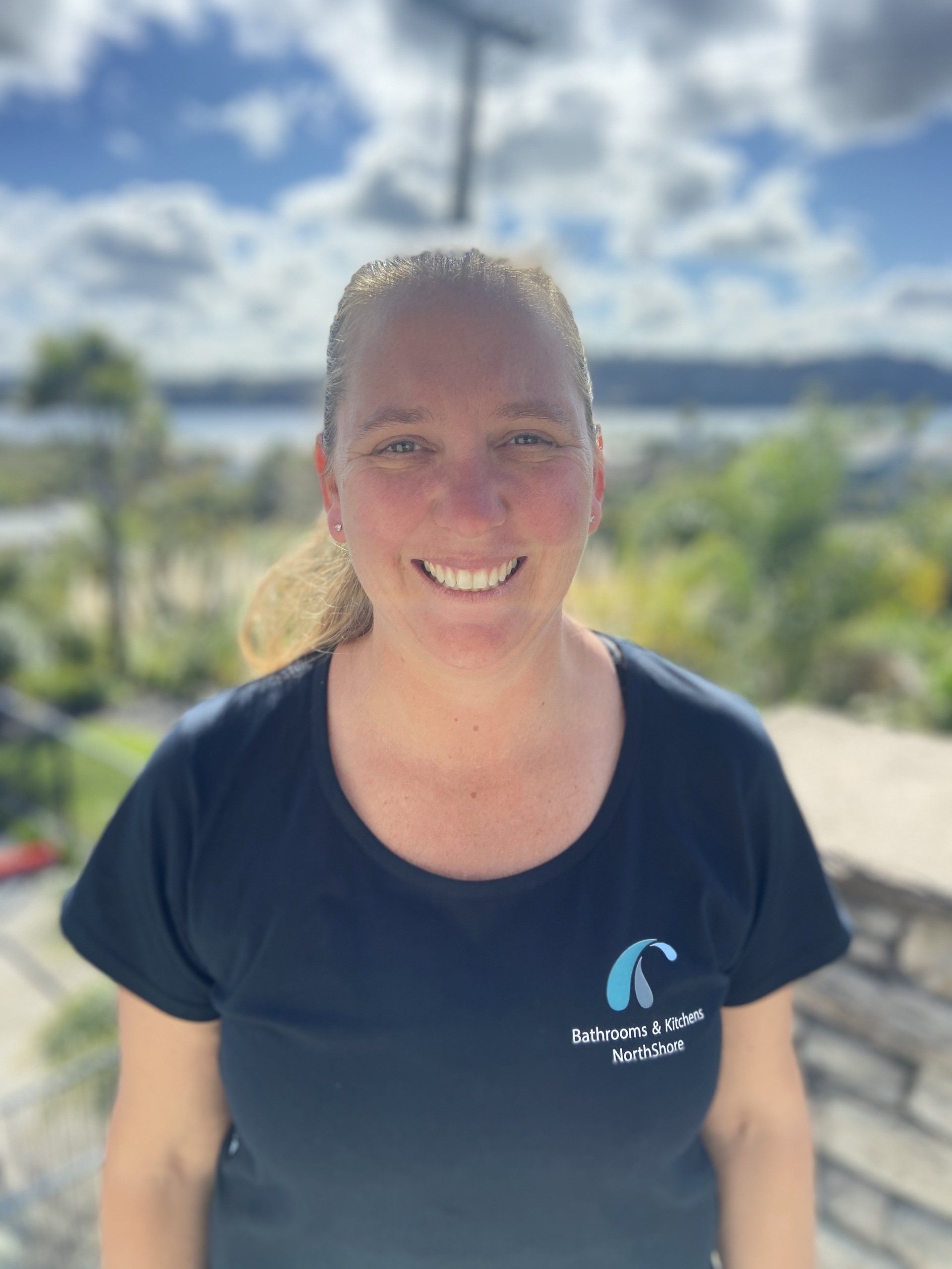 A woman wearing a blue shirt with the letter c on it