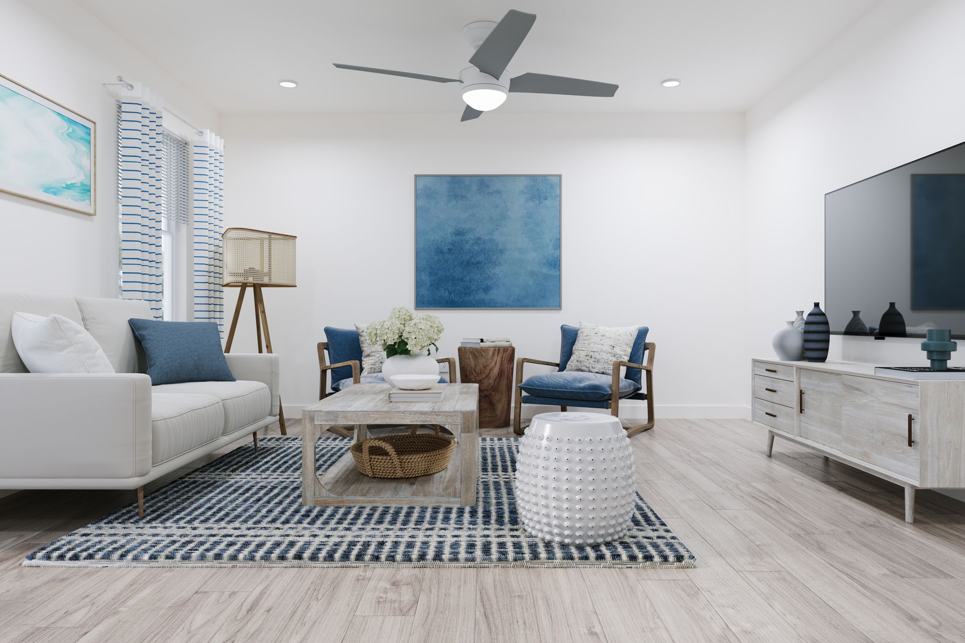 Bright modern living room with white sofa, blue chairs, patterned rug, and ceiling fan