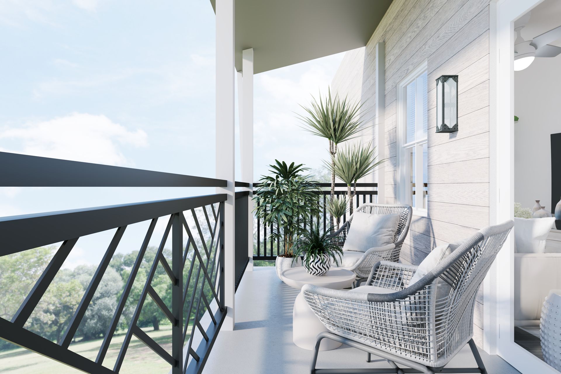 White balcony with wicker chairs, potted plants, and a view over a wooded landscape