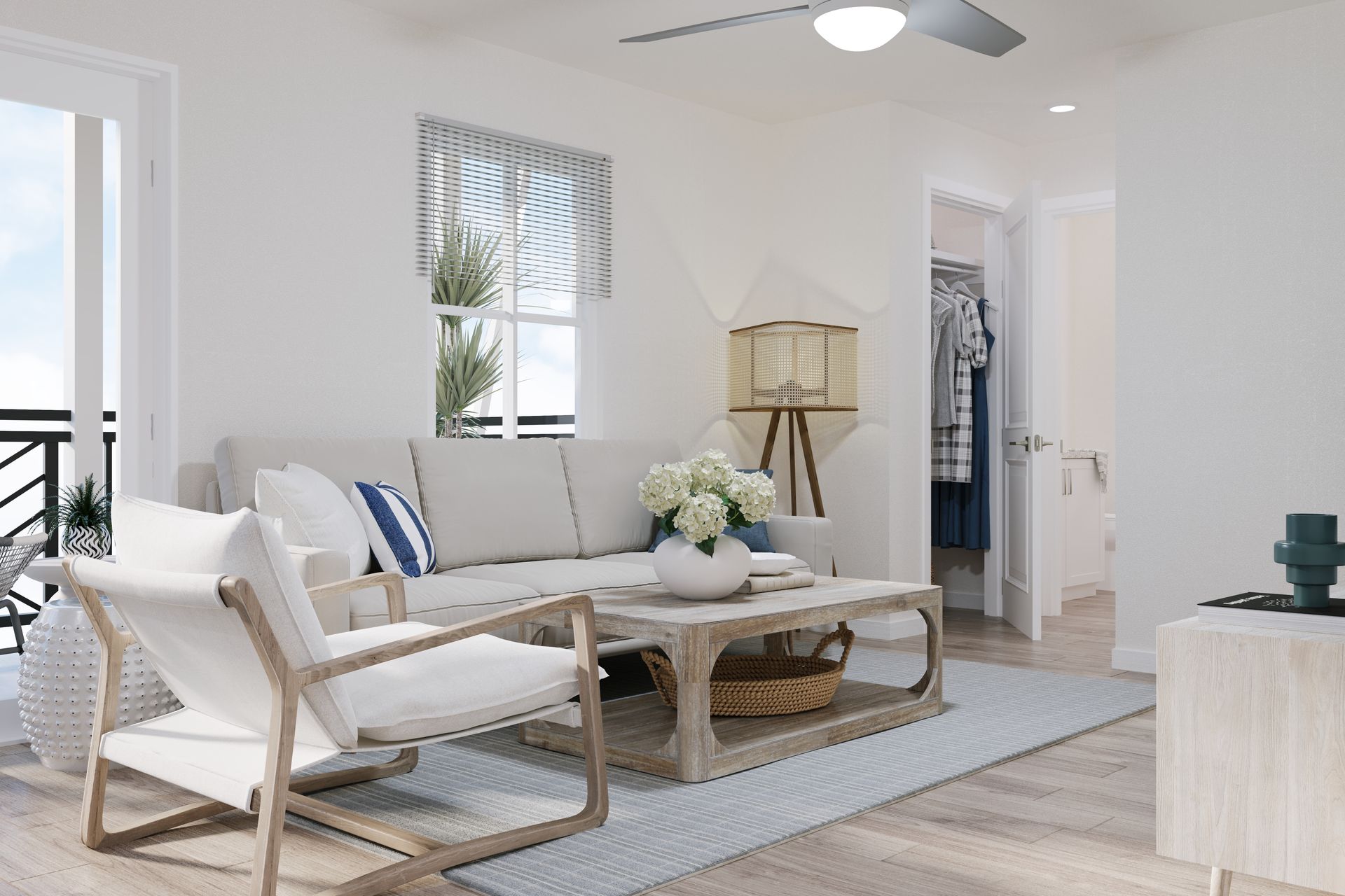 Bright, airy living room with white furniture, light wood accents, and a ceiling fan