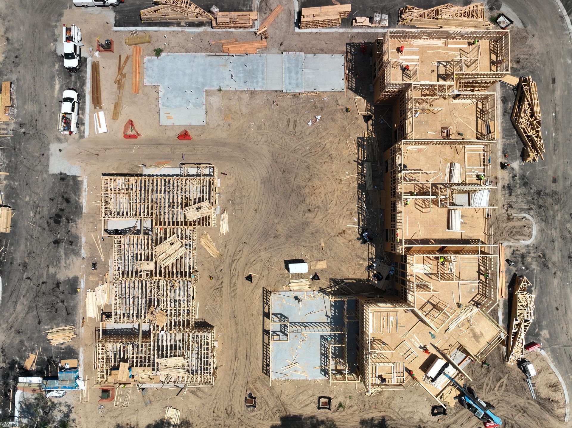 Aerial view of an active construction site with excavators, materials, and partially built structures.