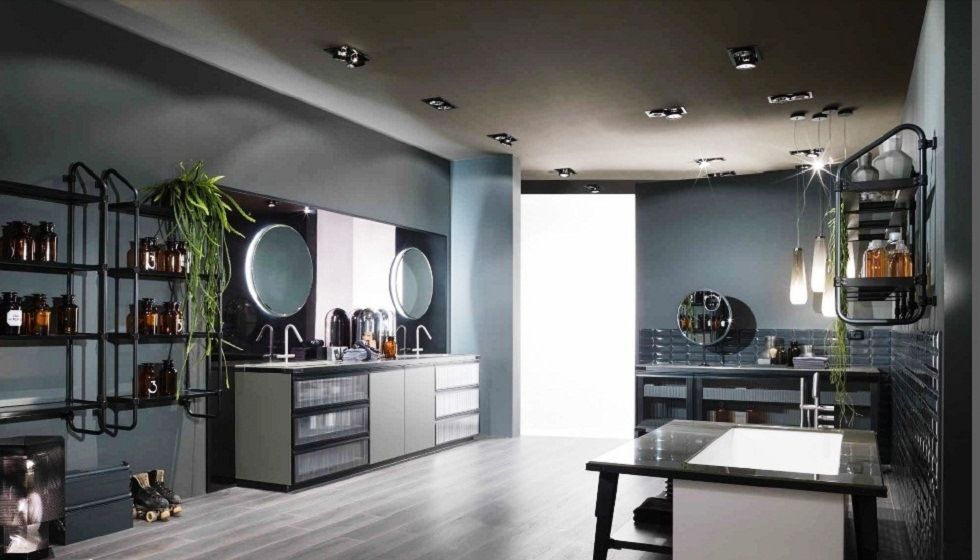 Bagno  di colore grigio con postazioni per lo styling, specchi, mensole e un tavolo centrale sotto le luci a soffitto.