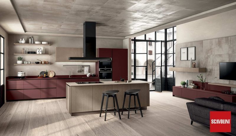 Cucina e soggiorno moderni a pianta aperta con mobili rossi, sgabelli sull'isola e ampie finestre.
