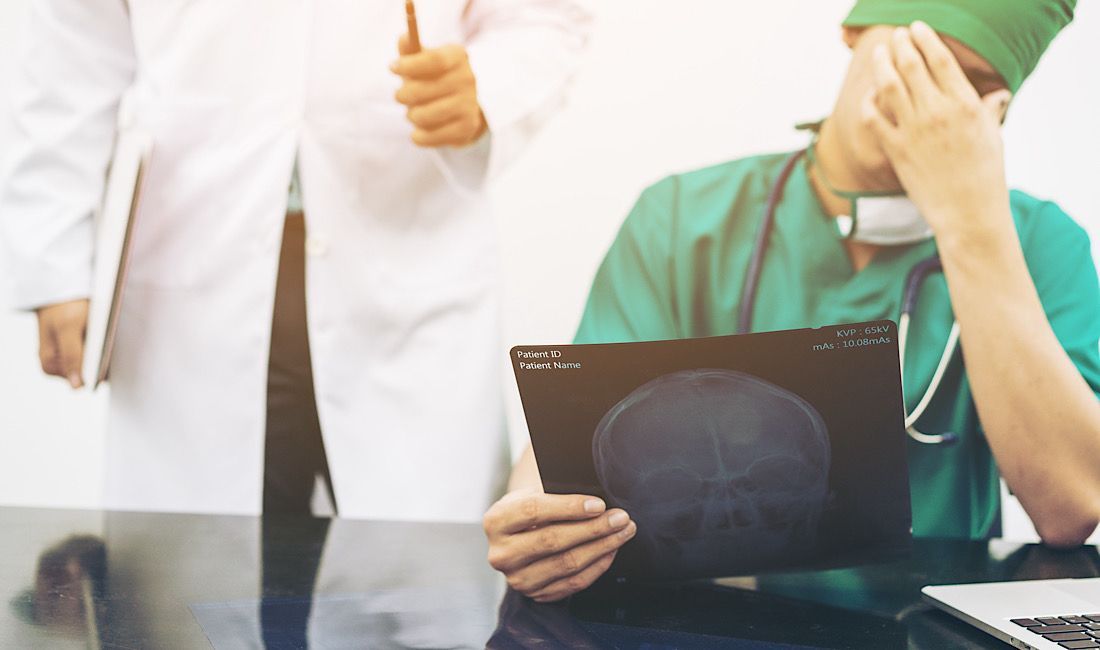 Radiologist and surgeon review an xray of a human's skull in Pittsburgh, PA.