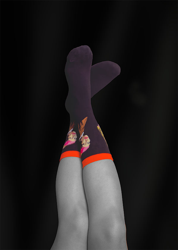 Legs in purple socks with ice cream cone design, orange cuffs, against black background.
