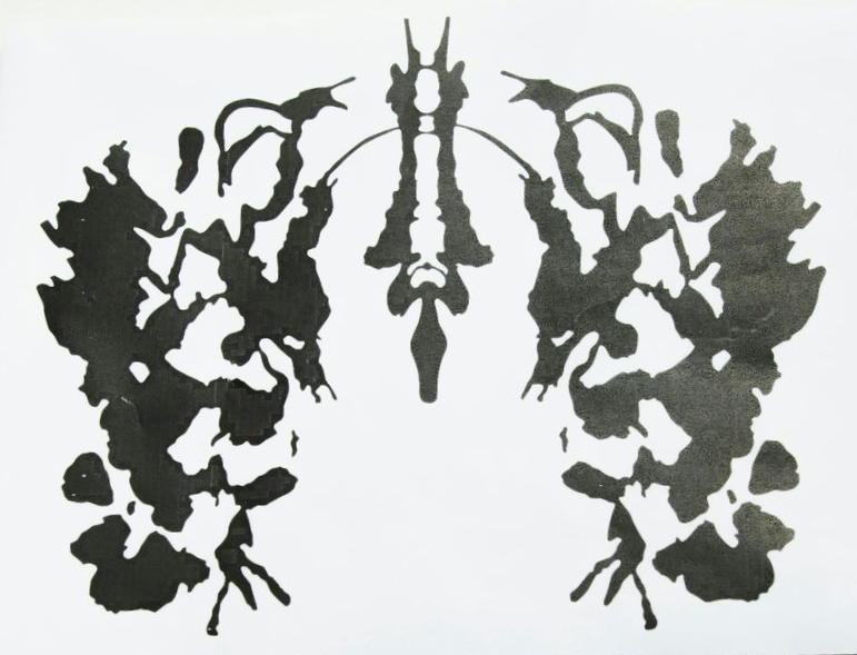 Inkblot in black, symmetrical, with varied shapes and textures. Used for psychological testing.