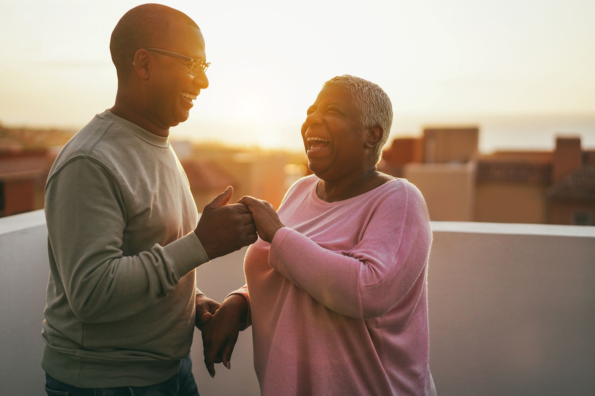 Two people smiling and touching fists on a rooftop at sunset Two people smiling and touching fists on a rooftop at sunset