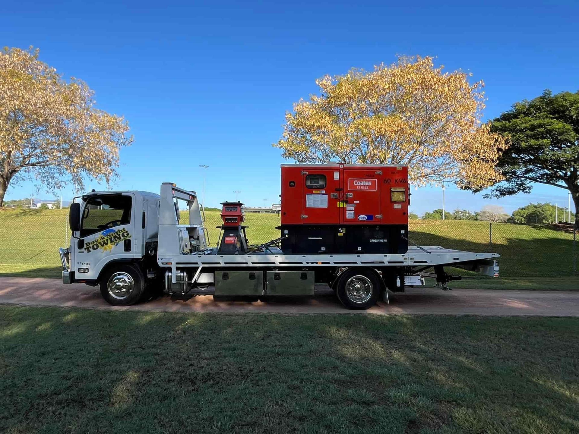 A Tow Truck With A Generator On The Back Is Parked In A Grassy Field  — Day & Night Towing & Transport In Condon, QLD