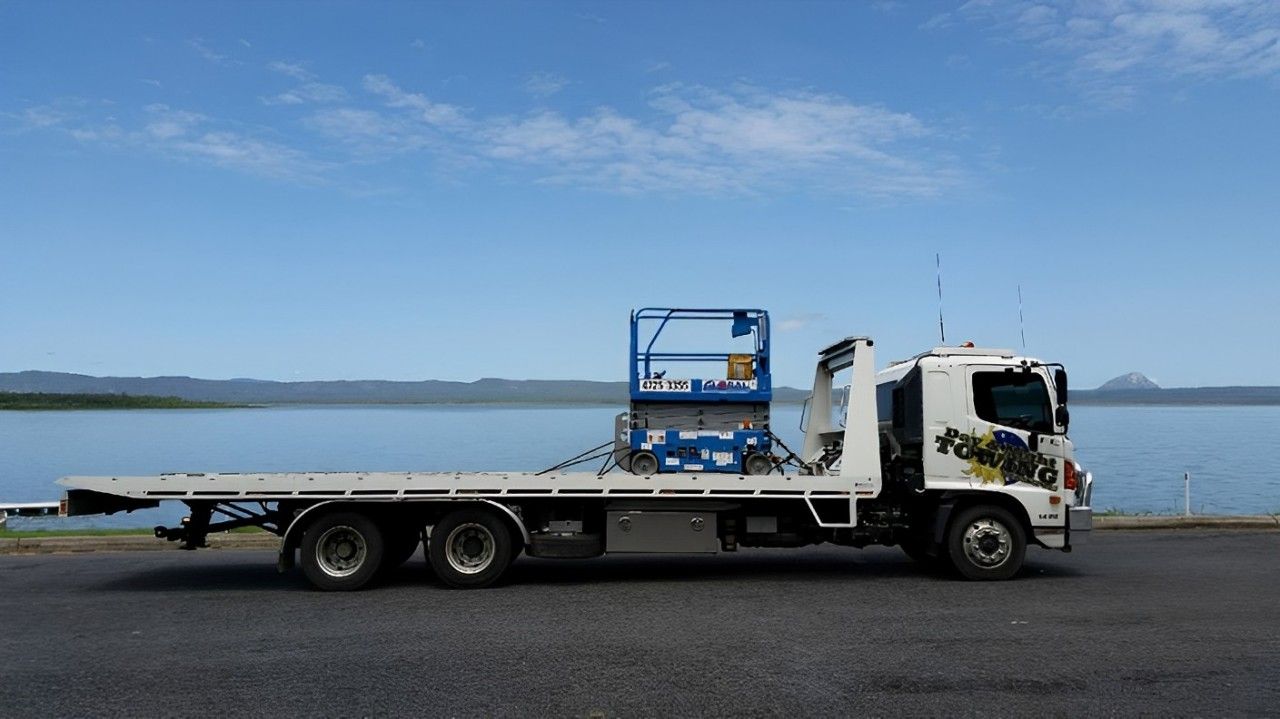 A Flatbed Truck With A Ladder On The Back Is Parked — Day & Night Towing & Transport In Condon, QLD