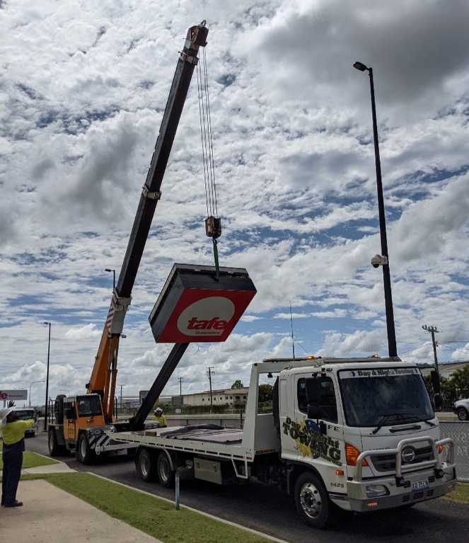 Crane Lifting TAFE Sign Onto A Truck — Day & Night Towing & Transport In Condon, QLD