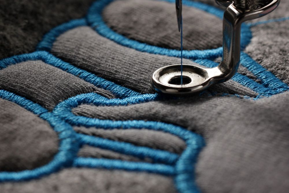 A Close Up Of A Sewing Machine Stitching On A Piece Of Fabric — Gympie Embroidery Services In Southside, QLD