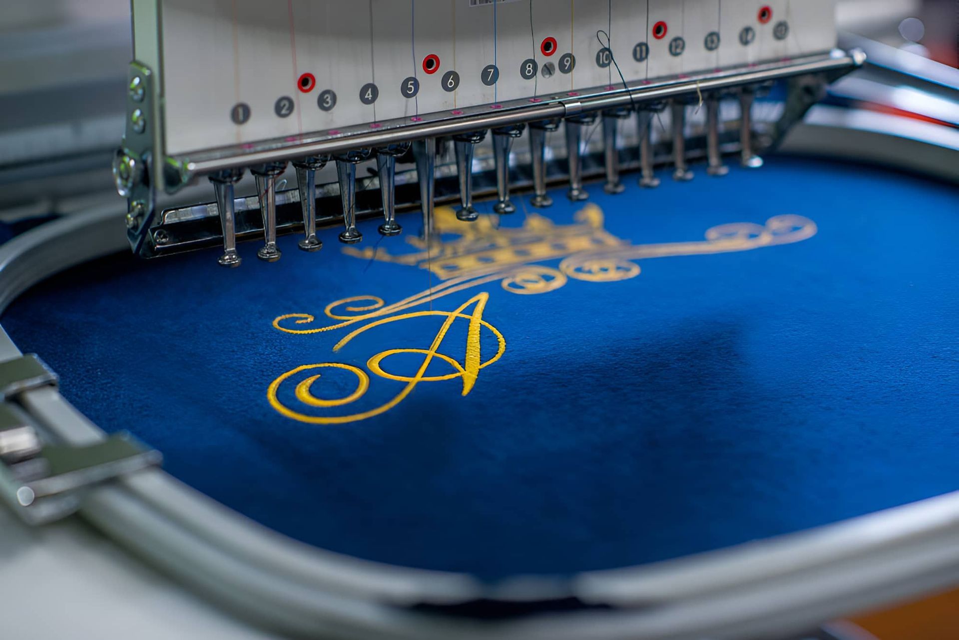 A Machine Is Embroidery A Letter A On A Blue Cloth — Gympie Embroidery Services In Southside, QLD