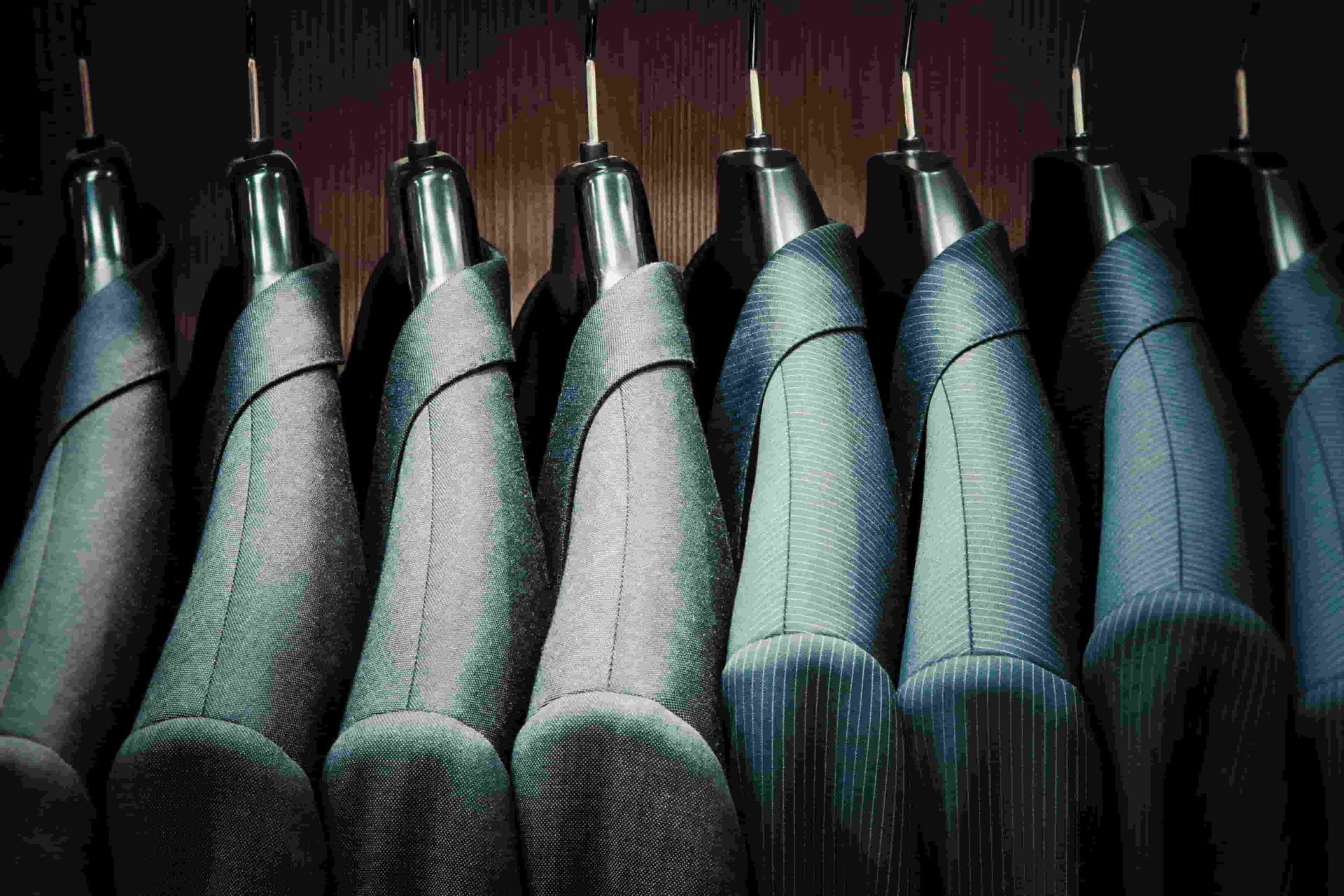 A Row Of Jackets Hanging On A Rack In A Closet — Gympie Embroidery Services In Southside, QLD