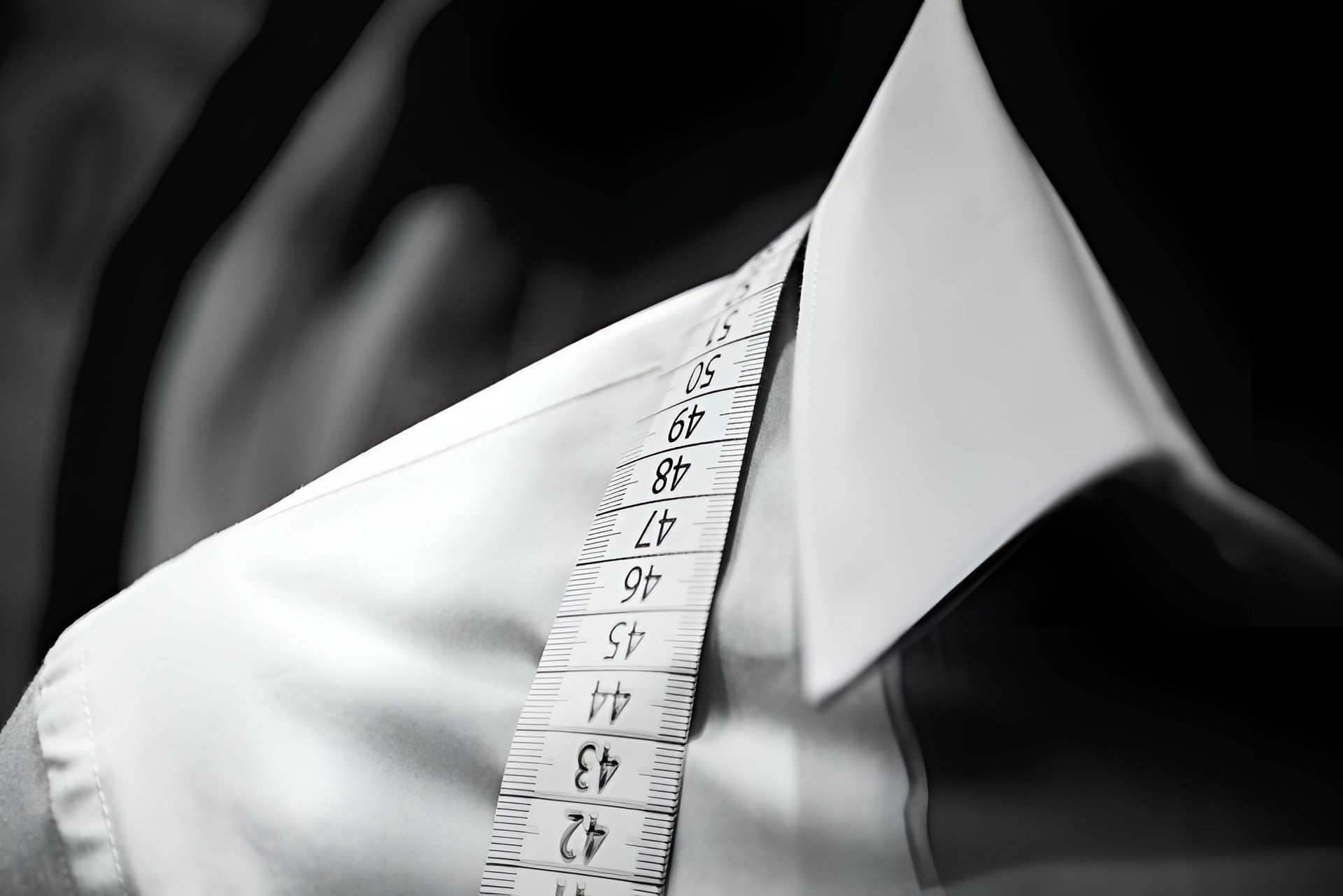 A White Shirt Is Being Measured With A Tape Measure — Gympie Embroidery Services In Southside, QLD