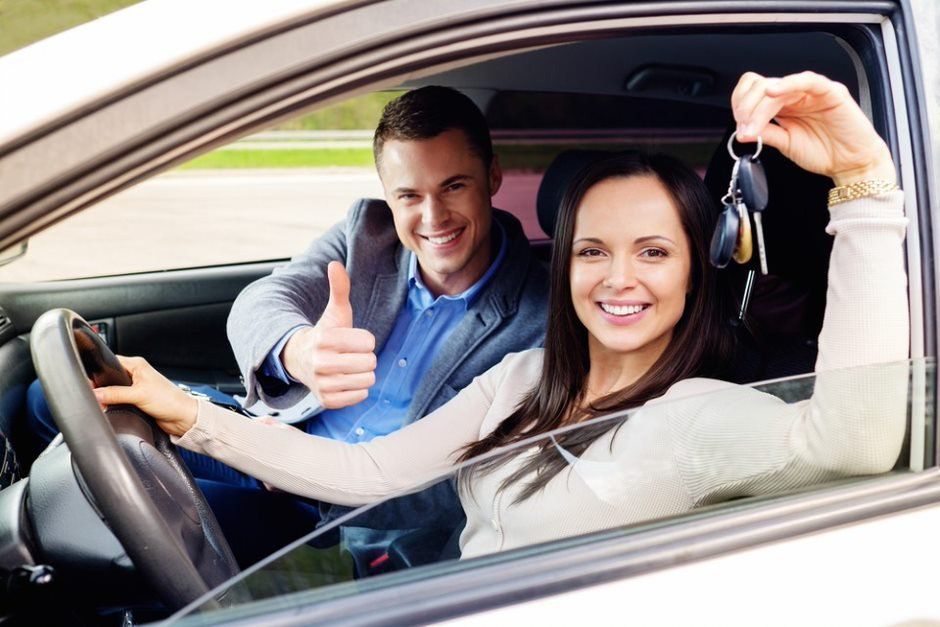 Happy Woman Holding a Car Key — Driving School in Townsville QLD
