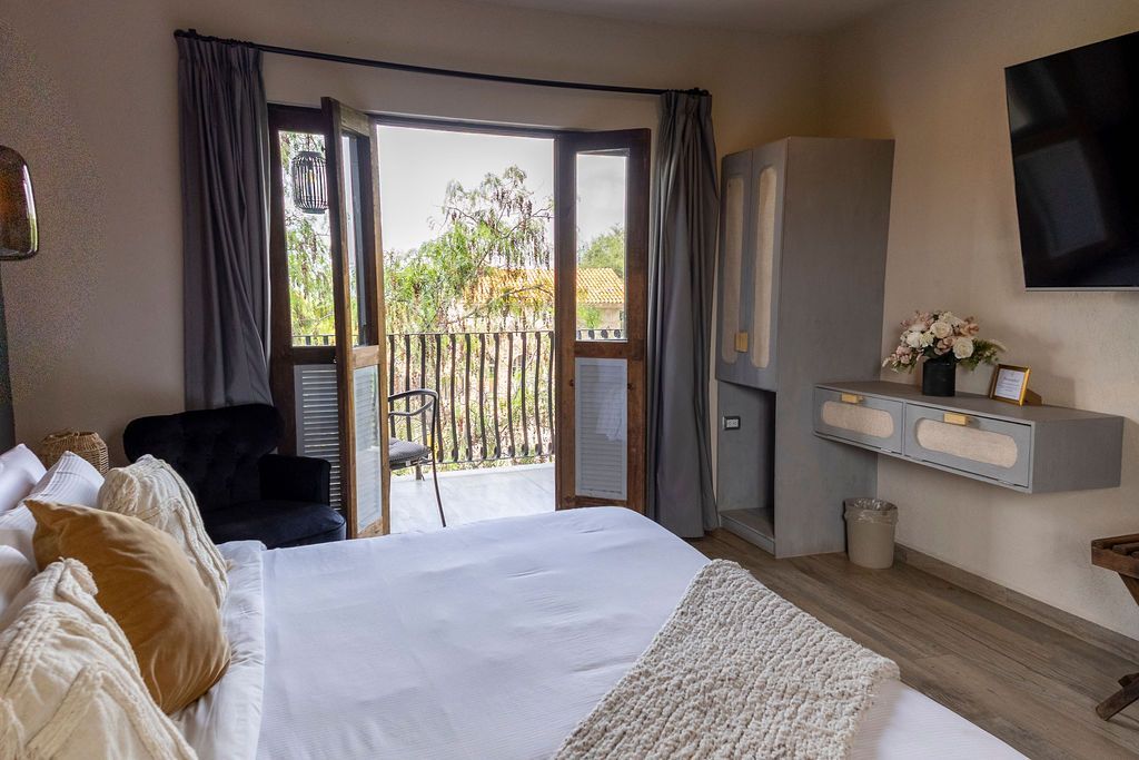 Bedroom with bed, balcony view, gray cabinet, and TV.