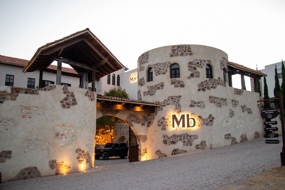 Stone building with archway entrance, lit sign 