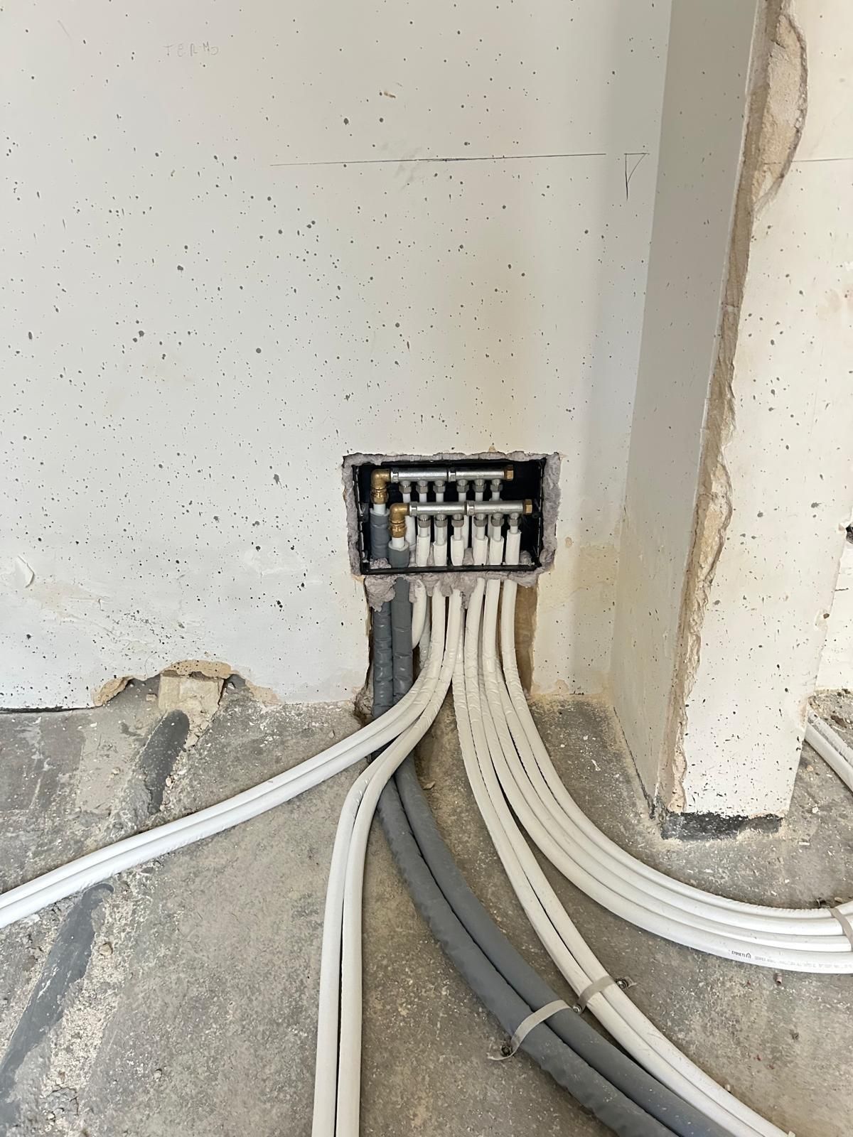 Fili elettrici che entrano in una scatola di derivazione a muro ricavata in un'apertura non rifinita in una parete interna.