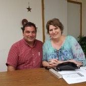 A man and a woman are sitting at a table.