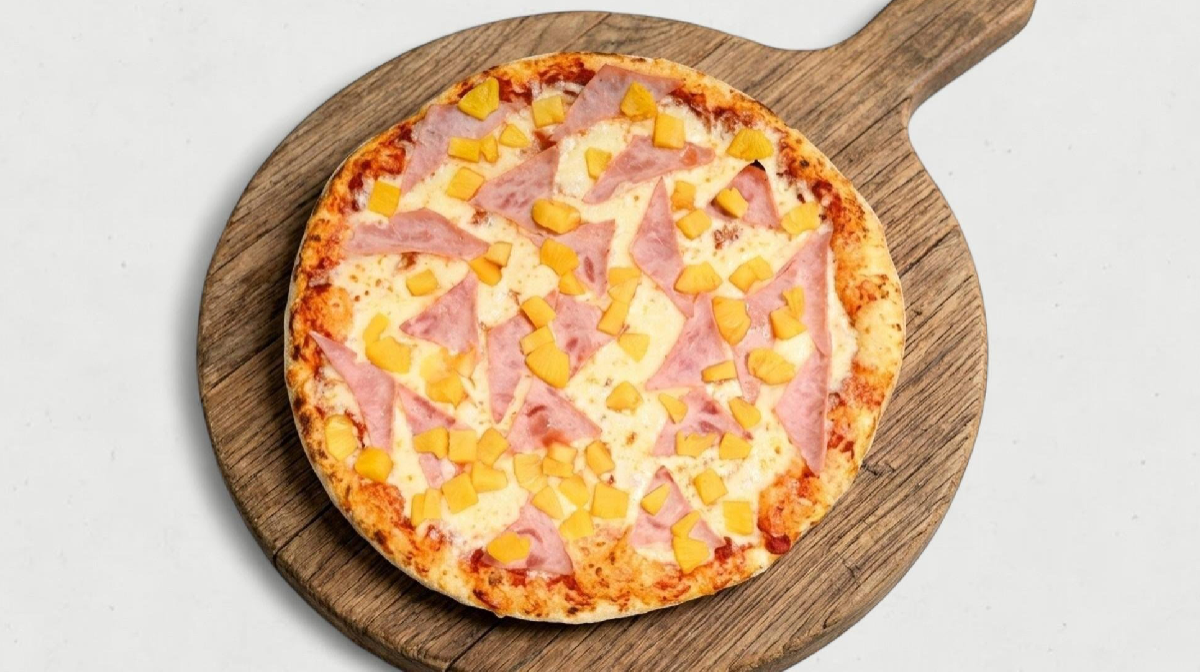 Small ham and cheese pizza on a wooden board over a white background