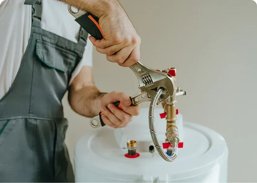 Worker using a spray gun to coat a white container in a workshop