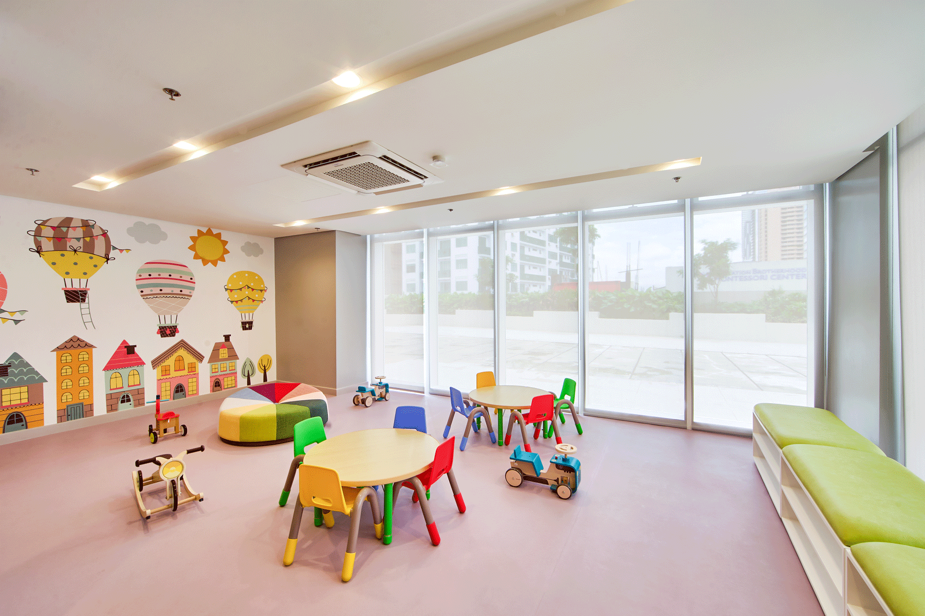 Colorful kid's playroom at our hotel near Greenhills with whimsical wall murals, activity tables, and educational toys