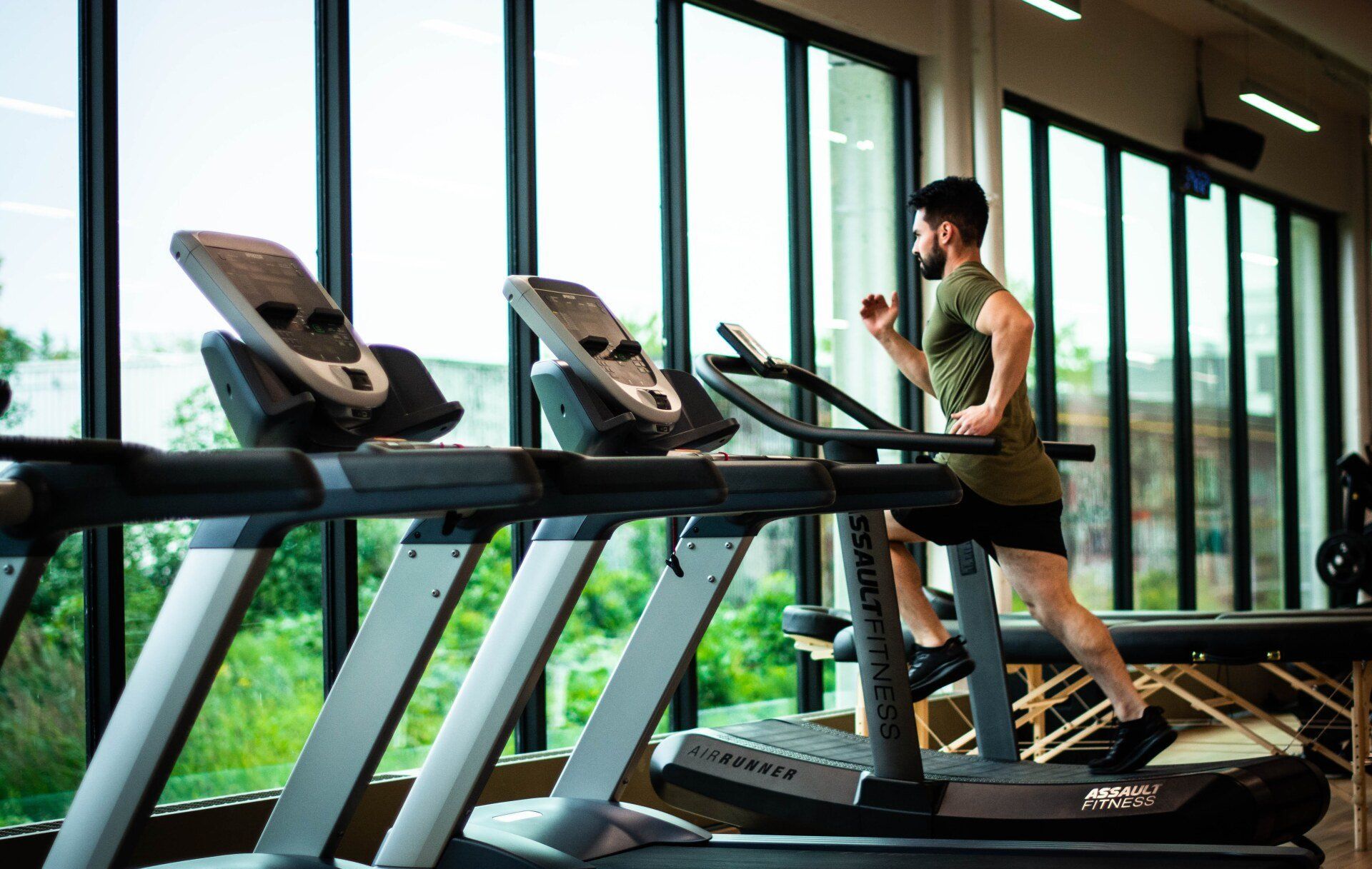 A man is running on a treadmill in a gym
