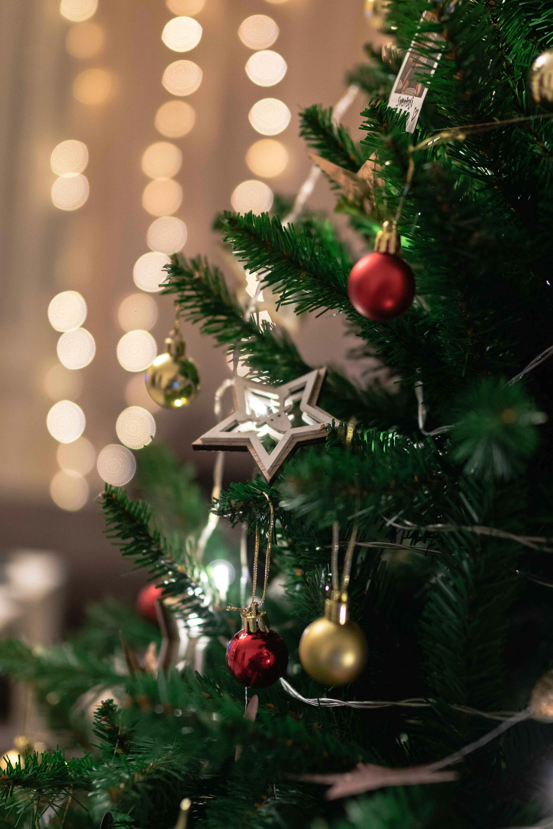 Decorated Christmas tree with red and gold ornaments and bokeh lights