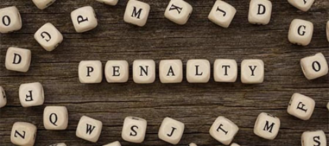 The word penalty is written in wooden blocks on a wooden table.