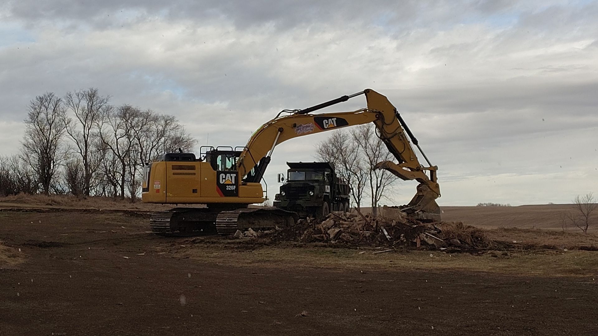 A large yellow excavator is parked in the snow.