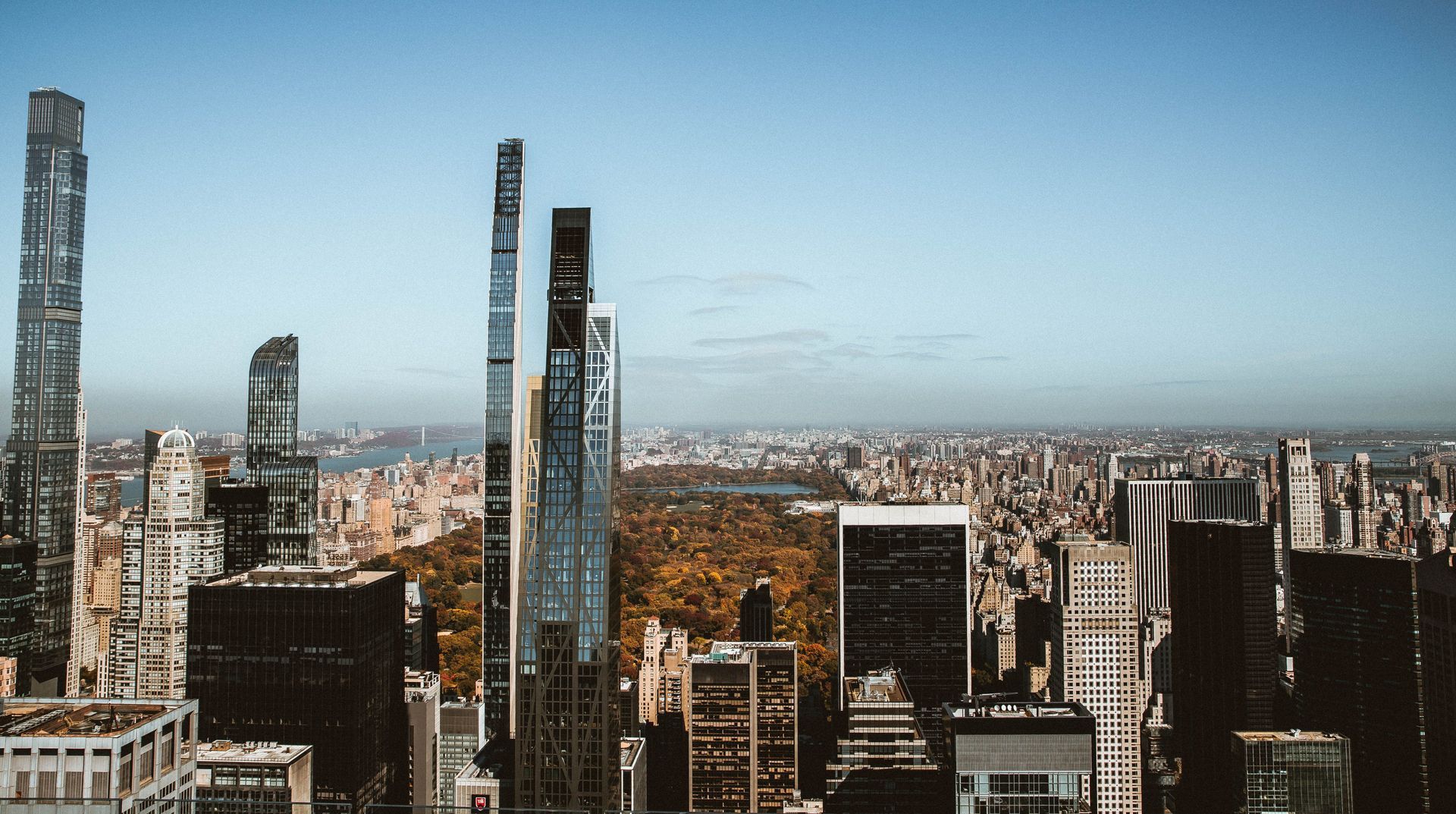 A manhattan skyline with tall modern skyscrapers under a clear blue sky.