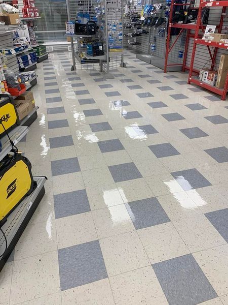 Shop floor with wet spots on a gray and white checkered tile pattern.