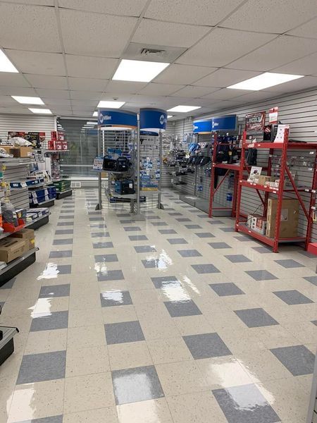 Interior of a hardware store with tile floors, displays, and products on shelves.