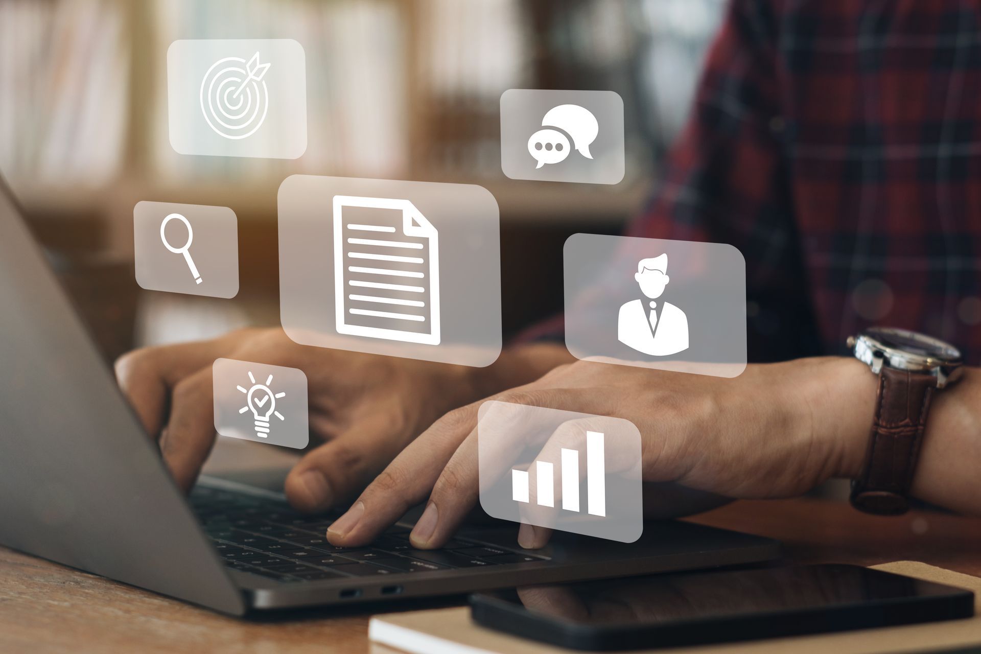 A man is typing on a laptop computer with icons coming out of it.