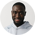 Smiling Black man in light blue hoodie, set against a white background.