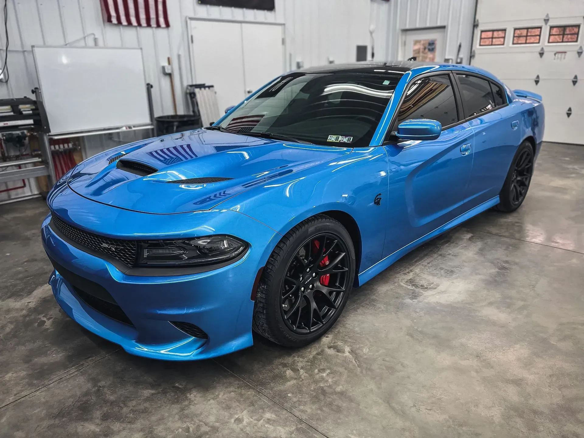 A blue dodge charger is parked in a garage.