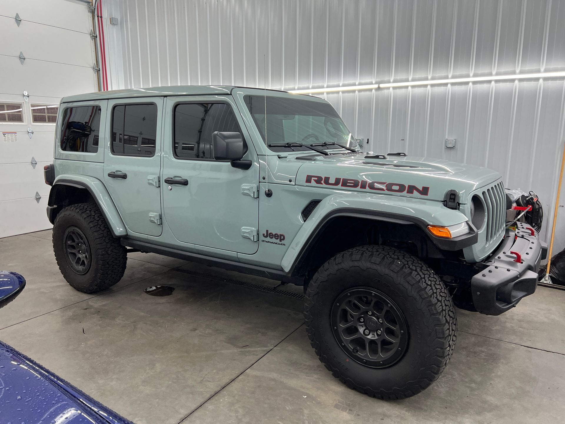 A jeep wrangler unlimited rubicon is parked in a garage.