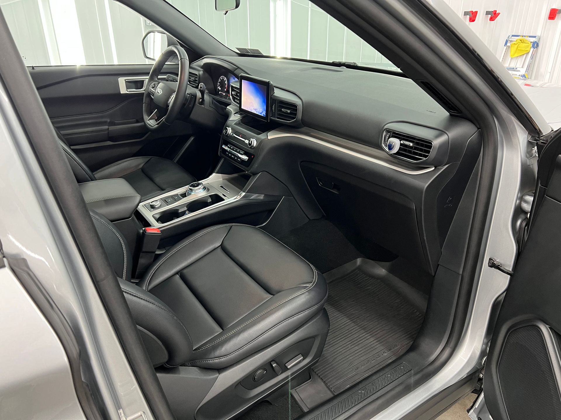 The interior of a ford explorer is shown with the door open.
