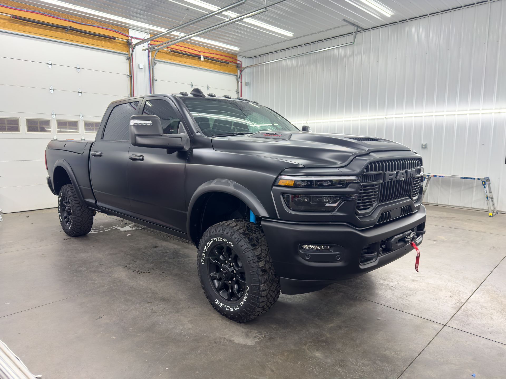 A black truck is parked in a garage.