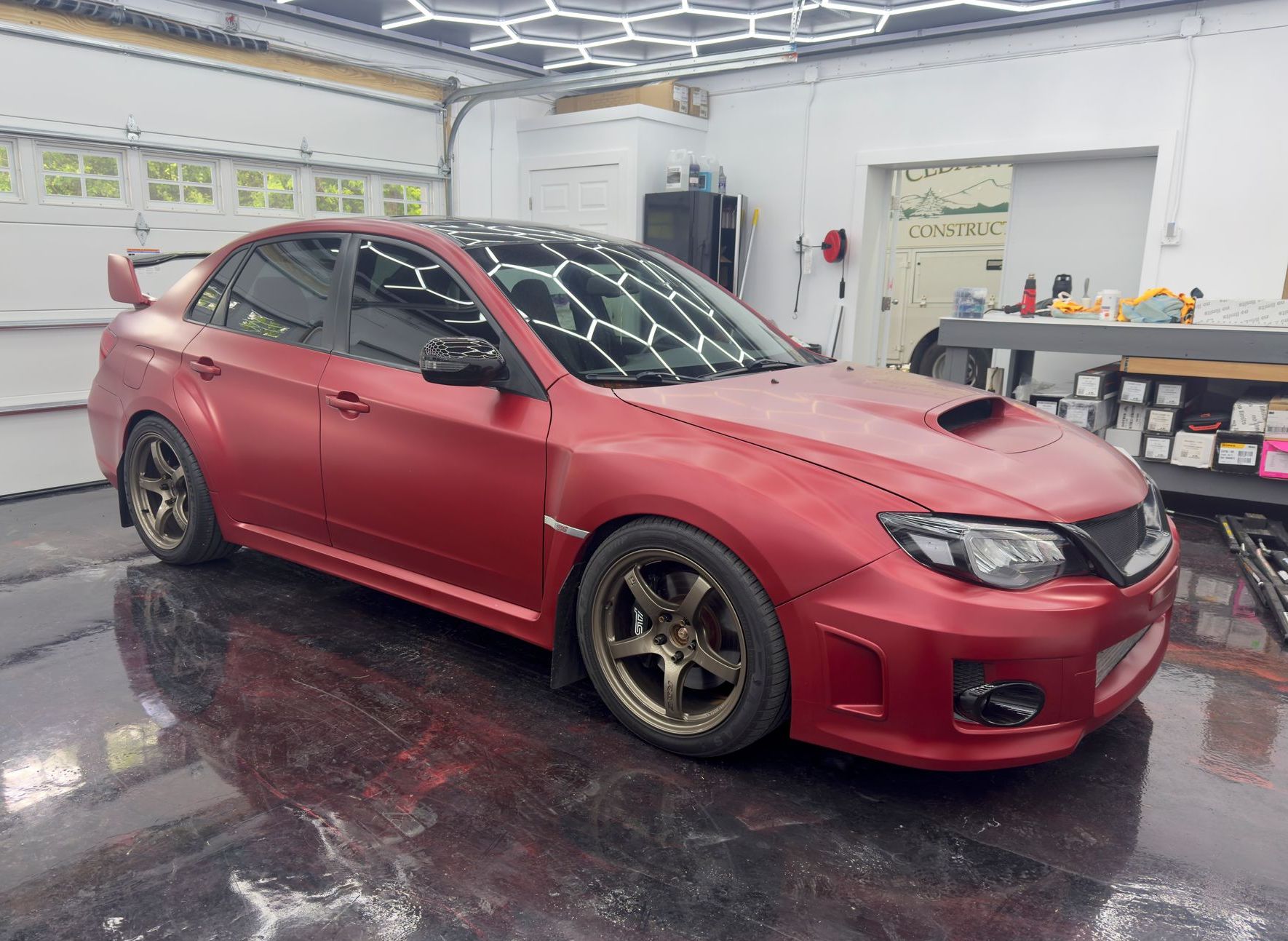 Red Subaru sedan parked inside a garage