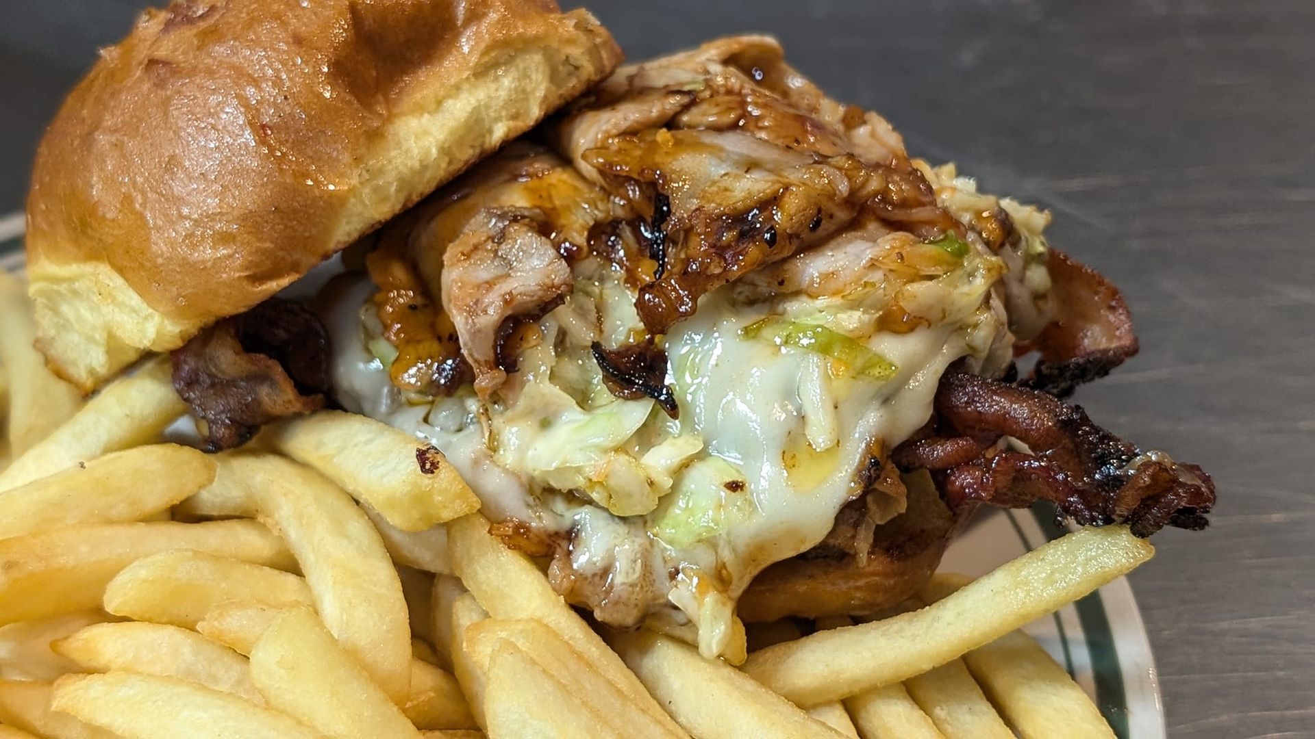 Burger with melted cheese and grilled meat on a plate with French fries