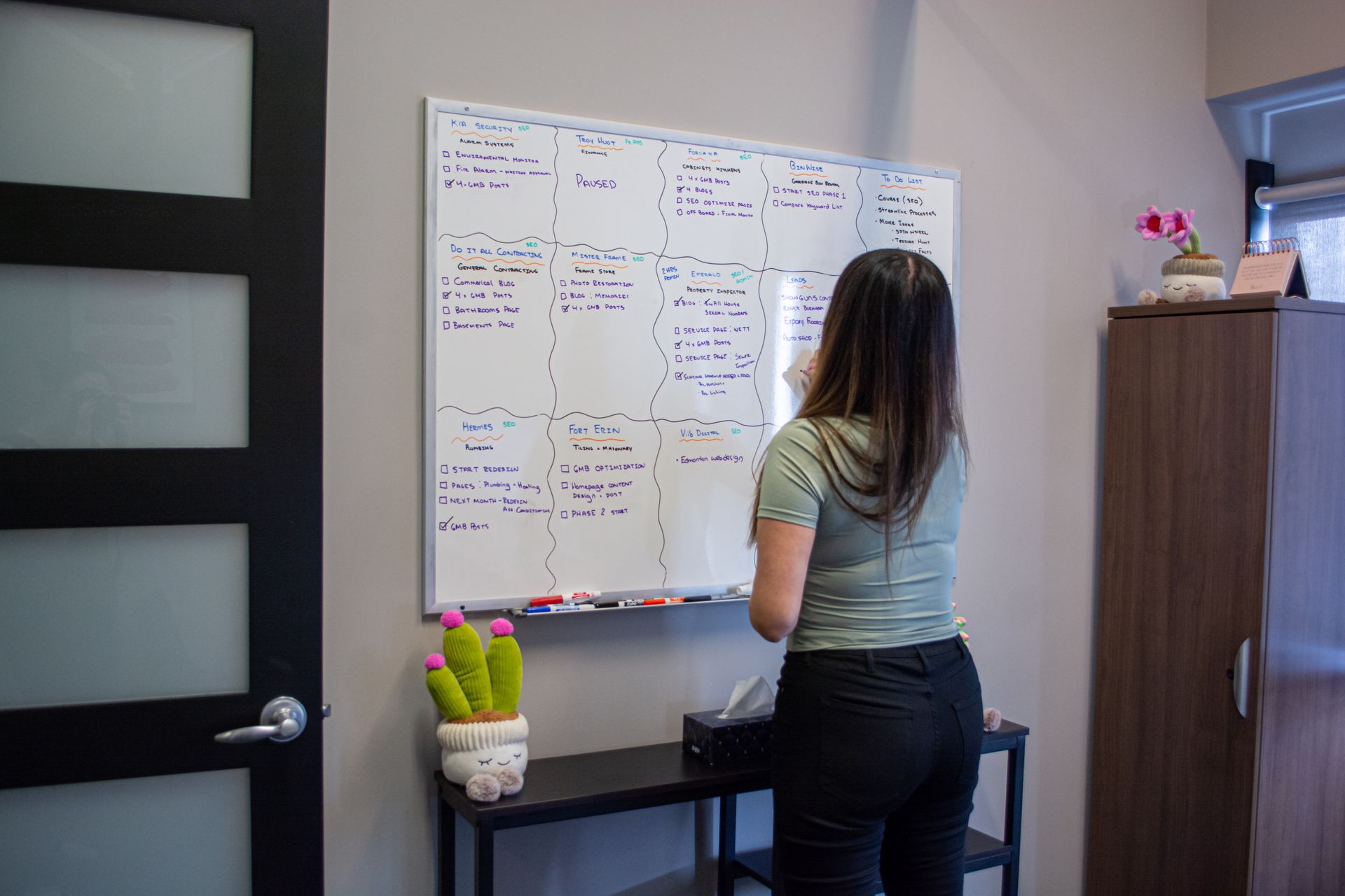 Woman writing on a whiteboard in an office room