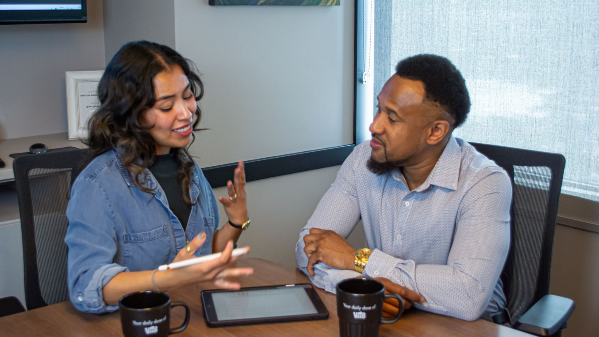 Two people having a collaborative discussion at a conference table.