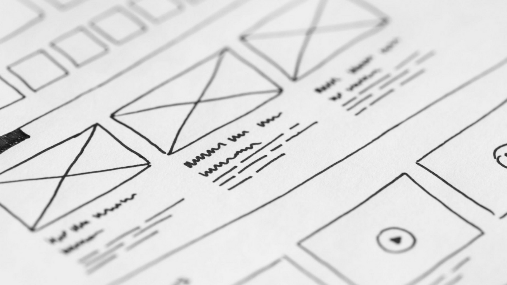 Sketch of a wireframe website layout with page sections, placeholders, and handwritten notes on paper