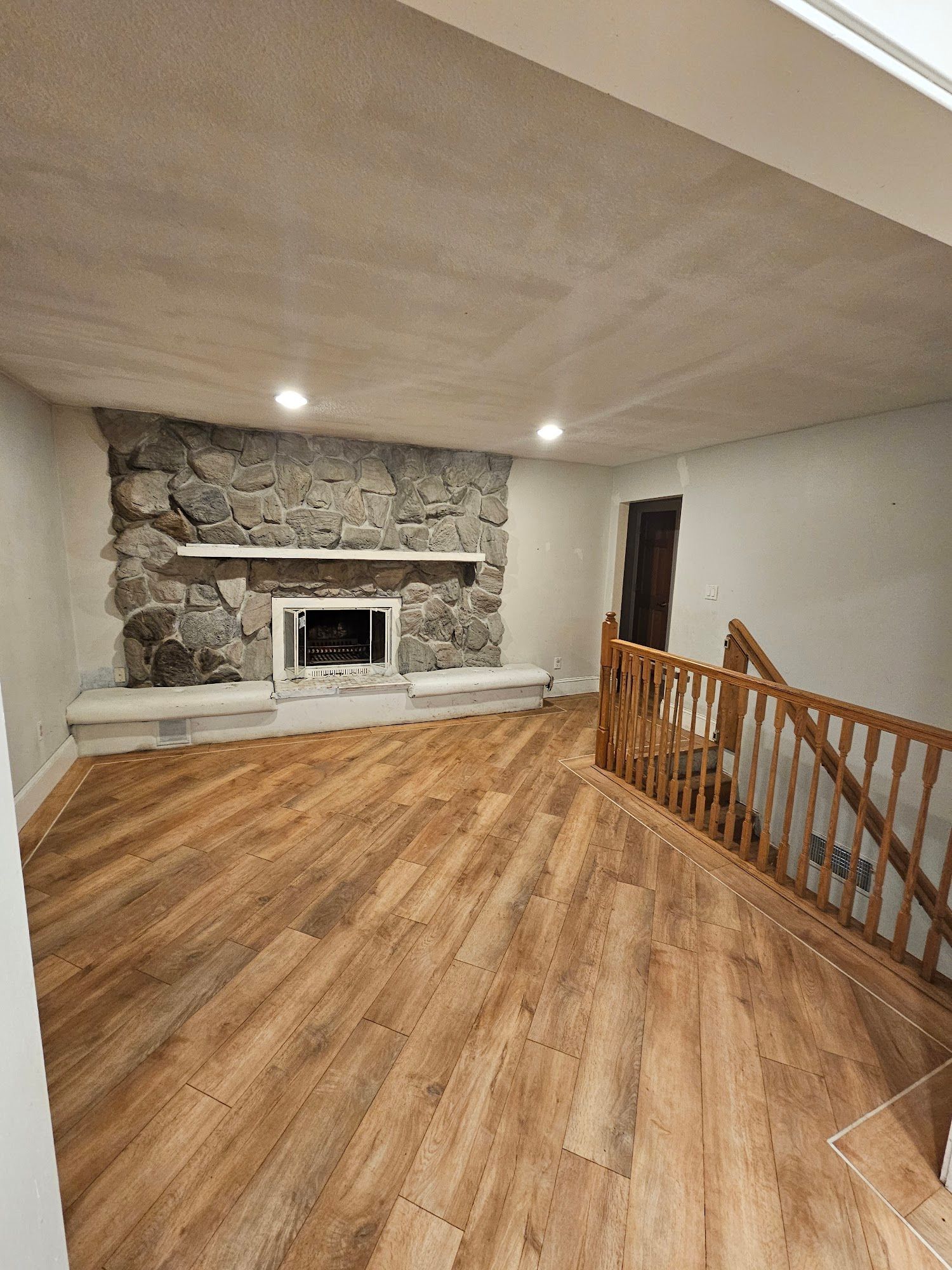 A living room with hardwood floors and a fireplace.