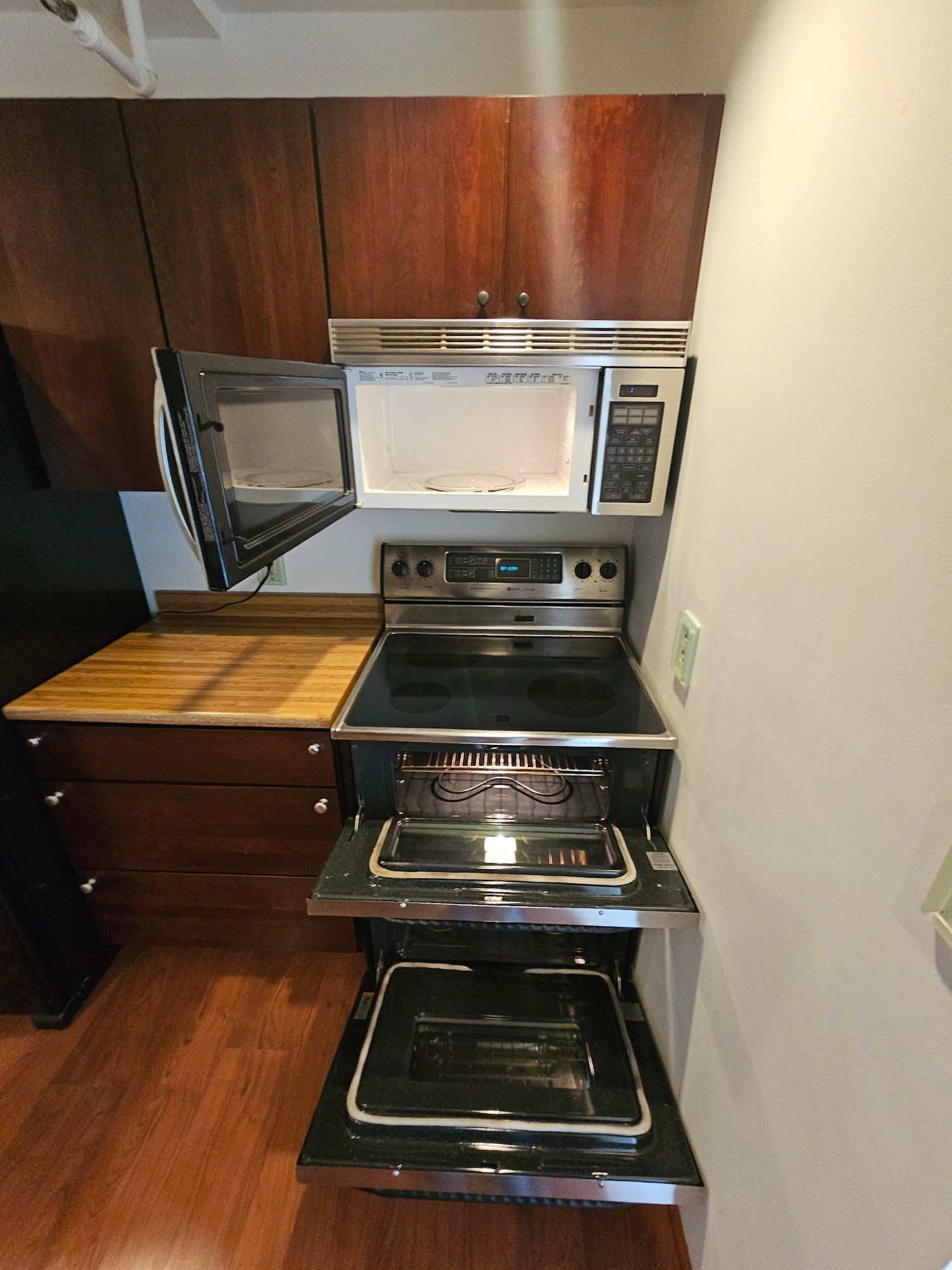 A kitchen with a stove top oven and a microwave